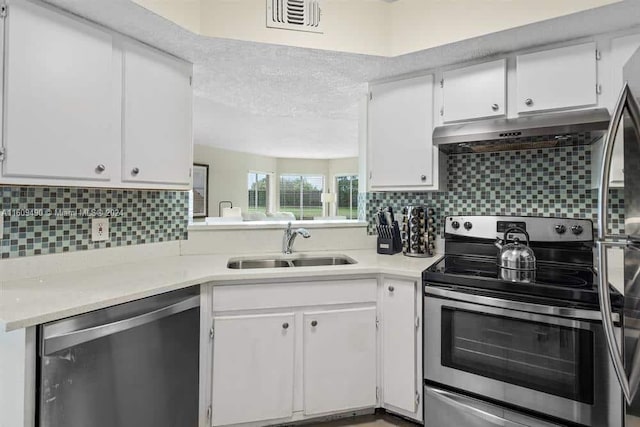 kitchen with white cabinetry, sink, stainless steel appliances, tasteful backsplash, and a textured ceiling