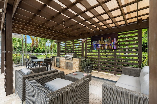 view of patio featuring grilling area, a pergola, an outdoor living space, and exterior kitchen