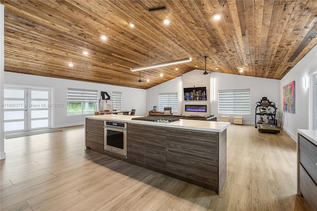 kitchen with a kitchen island, appliances with stainless steel finishes, wooden ceiling, and light wood-type flooring