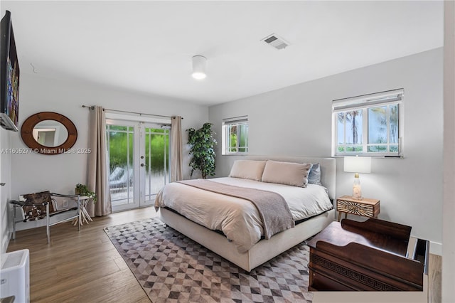 bedroom featuring french doors, access to exterior, and dark hardwood / wood-style flooring