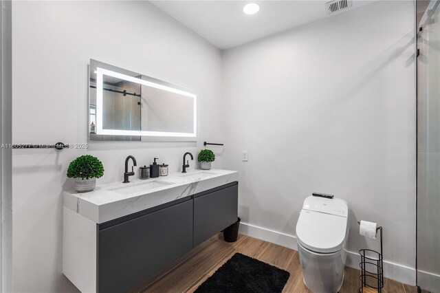 bathroom with wood-type flooring, toilet, and vanity