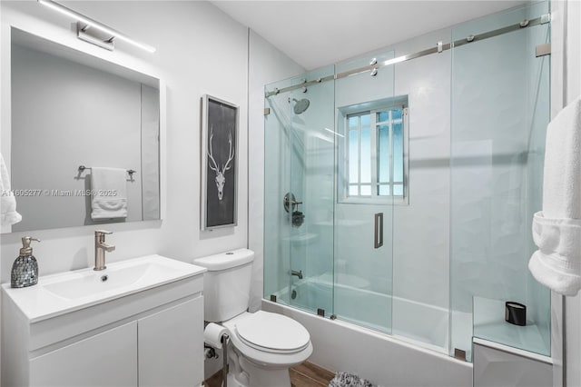 full bathroom with toilet, enclosed tub / shower combo, and vanity