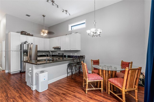 kitchen with stainless steel appliances, white cabinets, dark hardwood / wood-style flooring, and kitchen peninsula