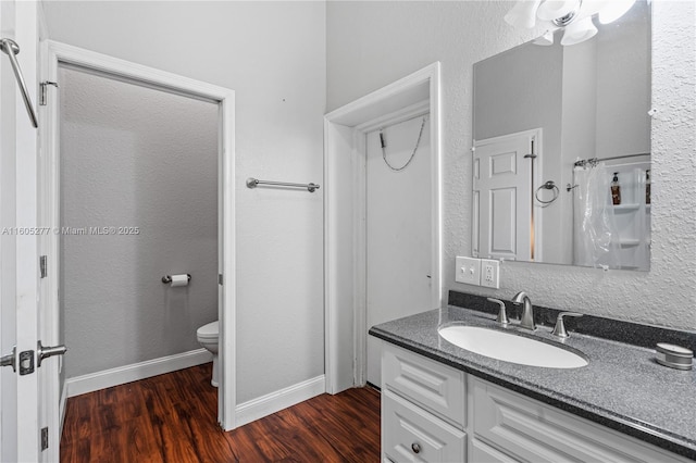 bathroom with vanity, wood-type flooring, and toilet