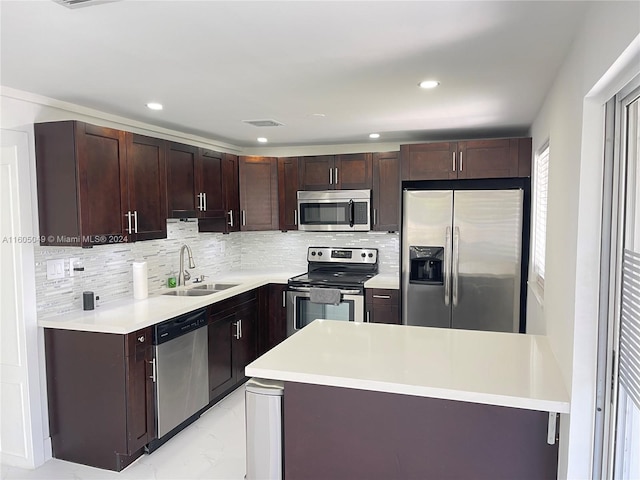 kitchen featuring backsplash, dark brown cabinets, sink, and appliances with stainless steel finishes