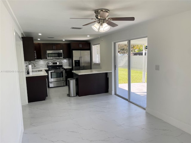 kitchen with sink, decorative backsplash, ceiling fan, appliances with stainless steel finishes, and dark brown cabinetry