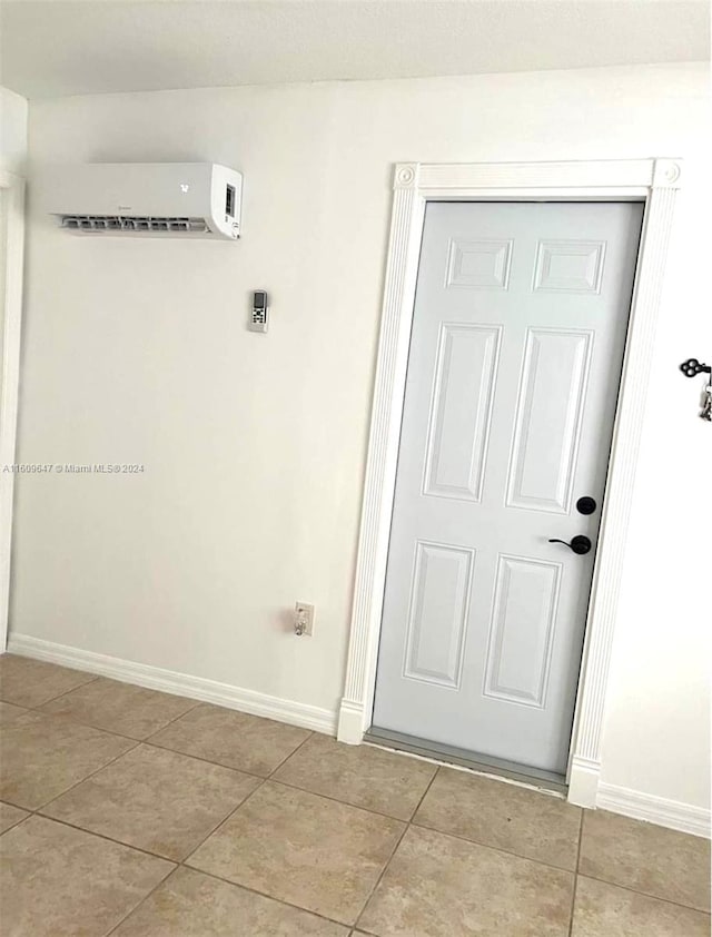 interior space with a wall mounted AC and light tile patterned floors