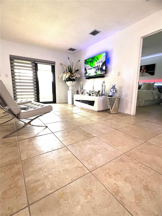 unfurnished living room featuring tile patterned flooring and a textured ceiling