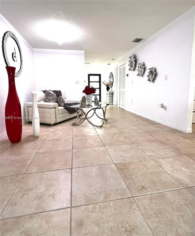 unfurnished living room with tile patterned flooring and a textured ceiling