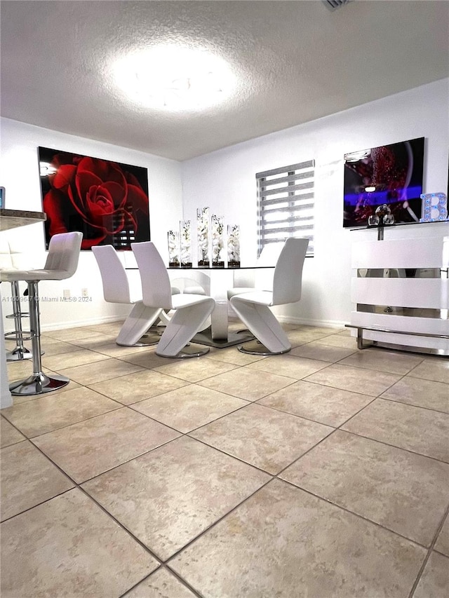 dining space with a textured ceiling and tile patterned flooring