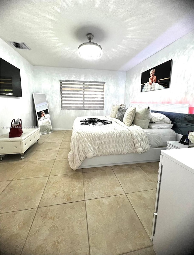 tiled bedroom featuring a textured ceiling