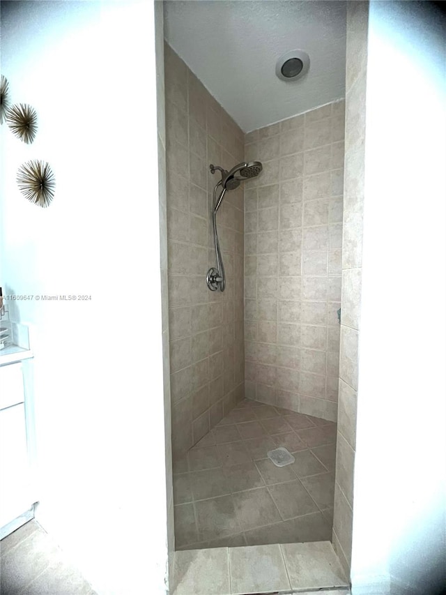 bathroom with vanity and a tile shower