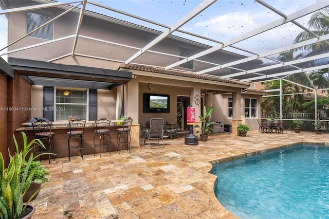 rear view of house featuring a patio and glass enclosure