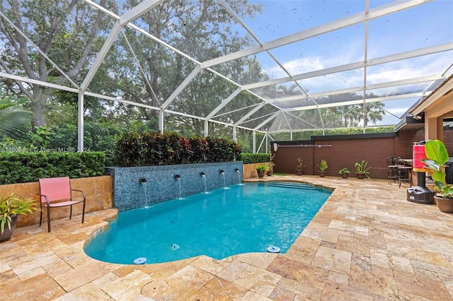 view of swimming pool featuring a patio, pool water feature, a hot tub, and a lanai