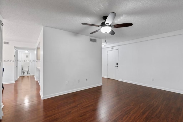 unfurnished room featuring ceiling fan, dark wood-type flooring, and a textured ceiling