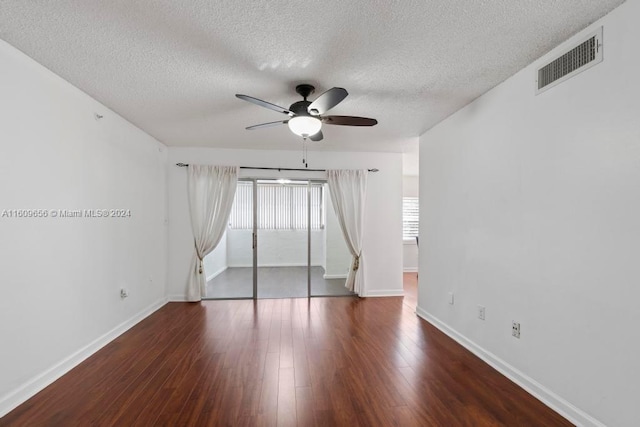 unfurnished room featuring ceiling fan, dark wood-type flooring, and a textured ceiling