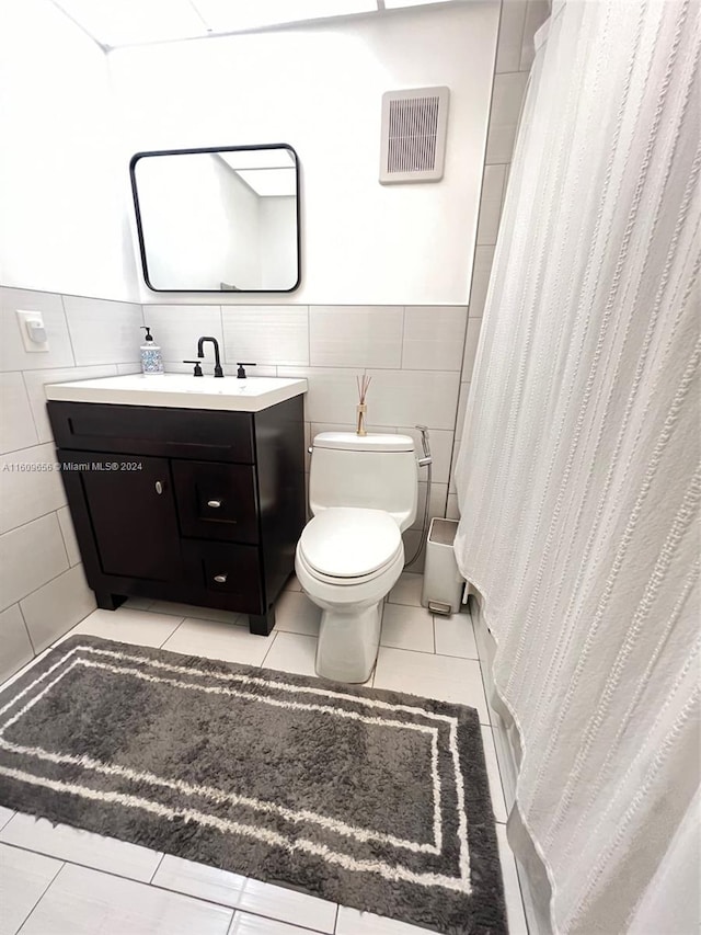 bathroom featuring vanity, tile patterned floors, a shower with curtain, tile walls, and toilet