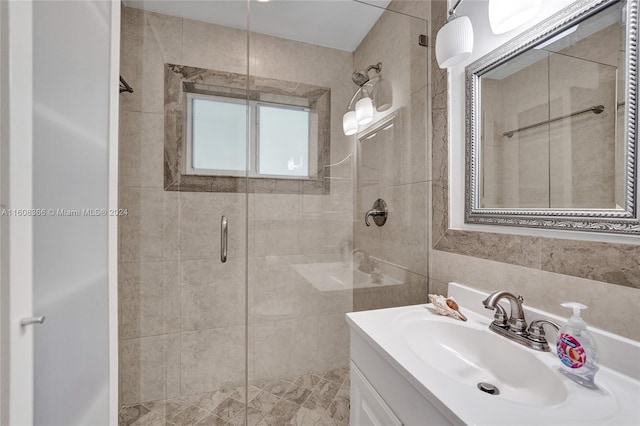 bathroom with a shower with shower door and vanity