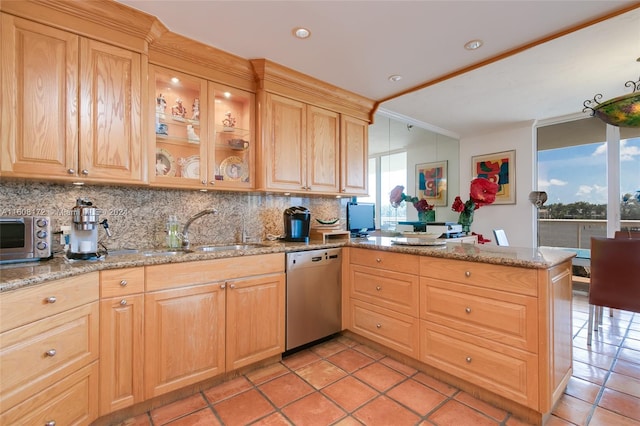 kitchen featuring sink, backsplash, light stone counters, stainless steel dishwasher, and kitchen peninsula