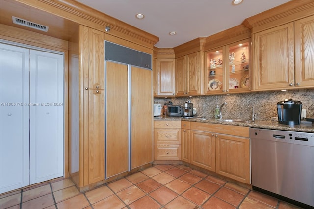 kitchen with light stone counters, stainless steel dishwasher, sink, and paneled built in refrigerator