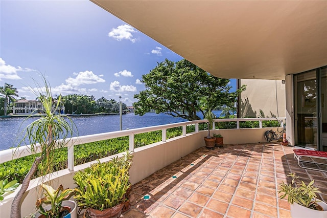 view of patio / terrace featuring a water view and a balcony