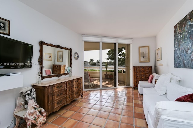 tiled living room featuring a wall of windows