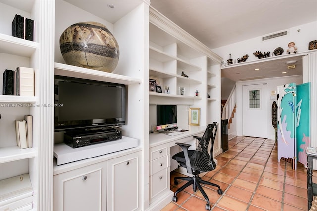 home office featuring light tile patterned floors, built in shelves, and built in desk