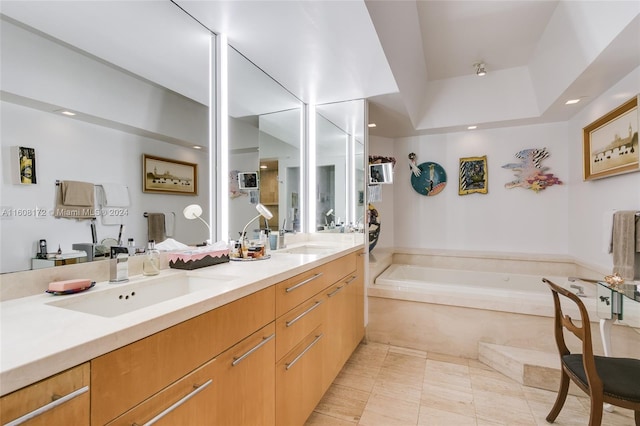 bathroom featuring tile patterned floors, vanity, and tiled bath