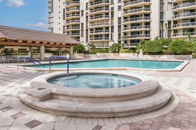 view of swimming pool with a hot tub