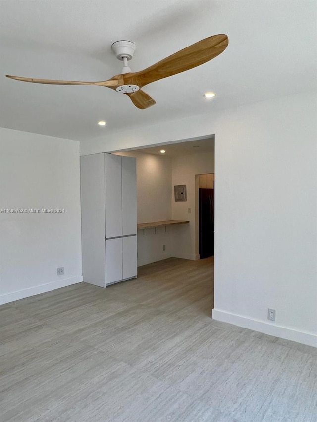 unfurnished room with ceiling fan and light wood-type flooring