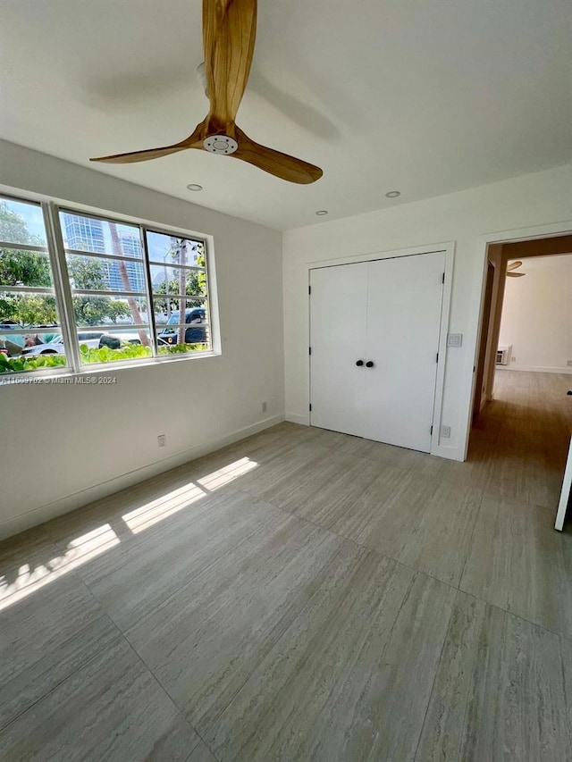 unfurnished bedroom with hardwood / wood-style flooring, ceiling fan, and a closet