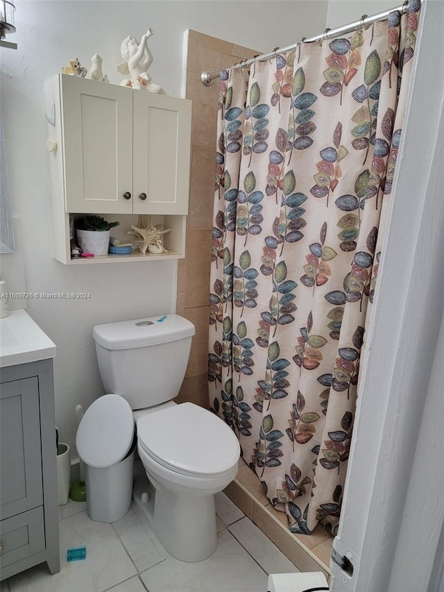 bathroom with tile flooring, toilet, and vanity