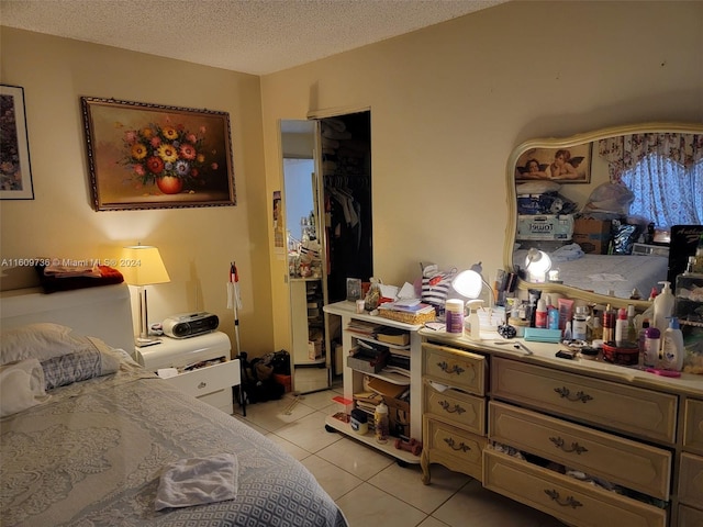 tiled bedroom featuring a closet and a textured ceiling