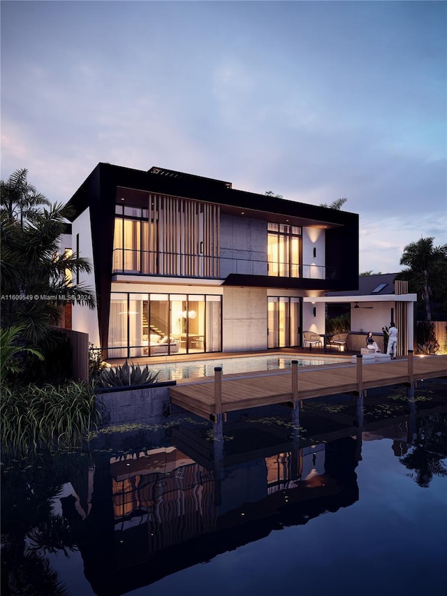 back house at dusk featuring a balcony