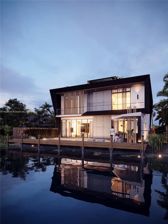 back house at dusk featuring a balcony