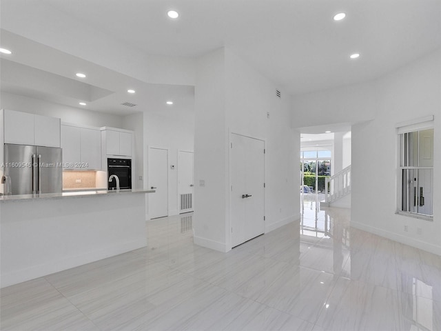 unfurnished living room featuring light tile floors