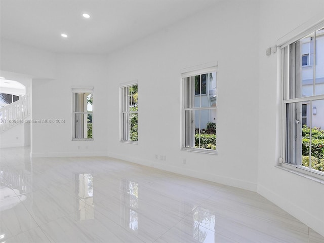 unfurnished room with a wealth of natural light and light tile floors