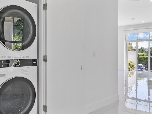 washroom with light tile floors and stacked washer / drying machine