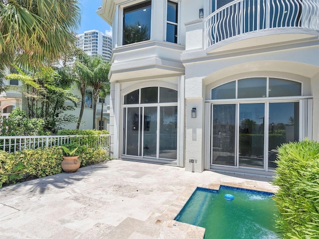 back of house with a patio area, a fenced in pool, and a balcony