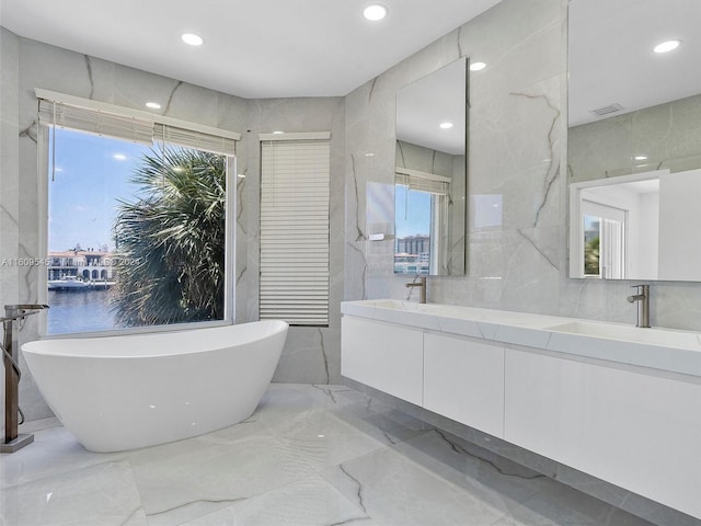 bathroom featuring tile walls, tile flooring, plenty of natural light, and double sink vanity