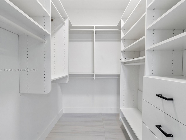 walk in closet featuring light tile floors