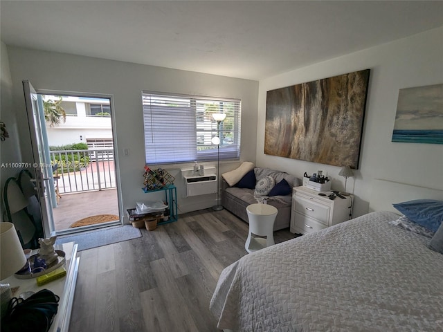 bedroom featuring access to outside, a wall mounted air conditioner, multiple windows, and dark hardwood / wood-style flooring