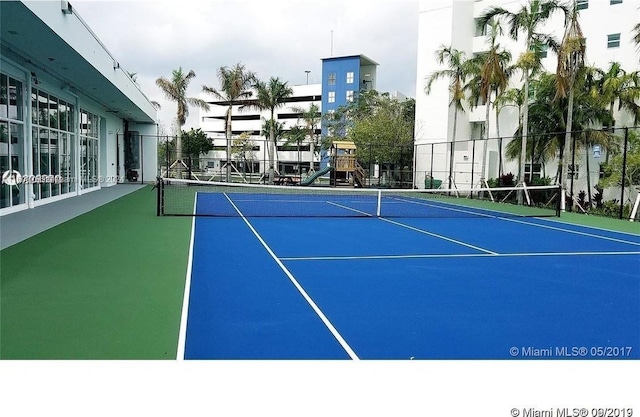 view of sport court with a playground and basketball hoop