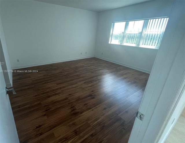 spare room with dark wood-type flooring