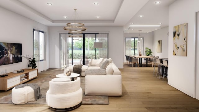 living room featuring a tray ceiling and light hardwood / wood-style flooring