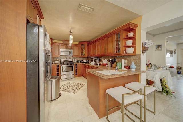 kitchen with stainless steel appliances, light tile floors, backsplash, and kitchen peninsula