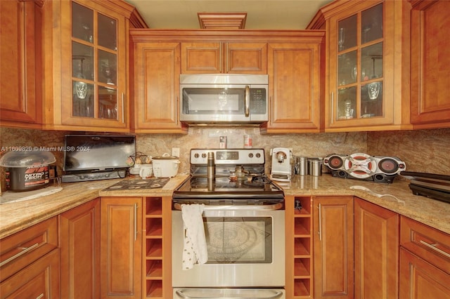 kitchen featuring light stone countertops, stainless steel appliances, and tasteful backsplash