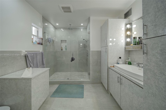 bathroom featuring walk in shower, tile flooring, tile walls, and vanity