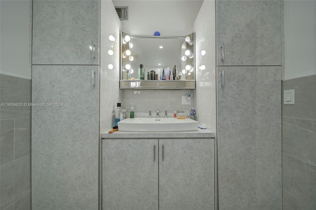 bathroom featuring tile walls and large vanity