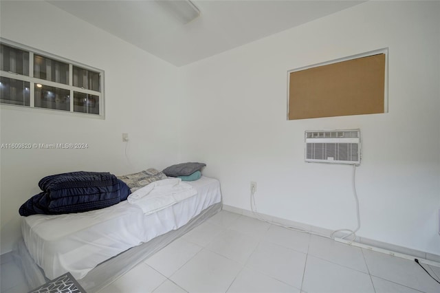 bedroom with light tile flooring and a wall mounted air conditioner